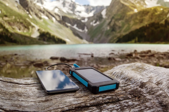山でモバイルバッテリーを使って携帯を充電している写真
