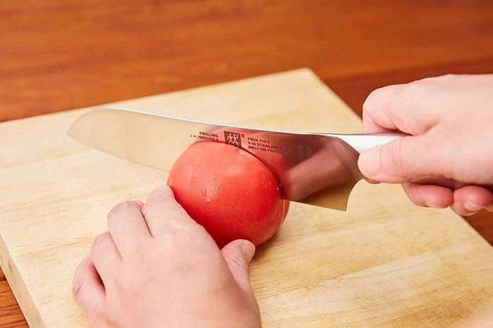 包丁でトマトを切る様子
