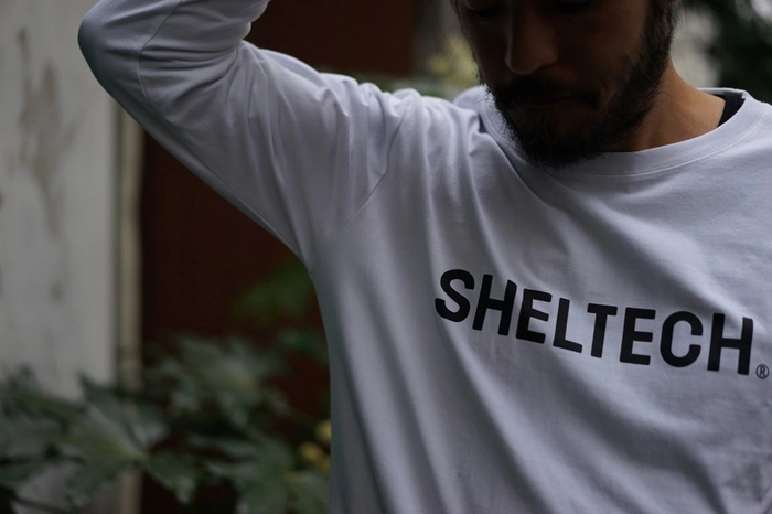 白いSHELTECH(R)のTシャツを着用している男性