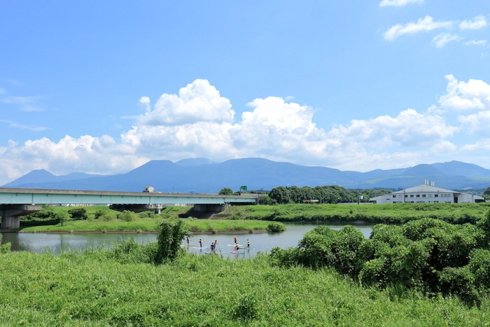 緑に囲まれた湖でサップをする人たち