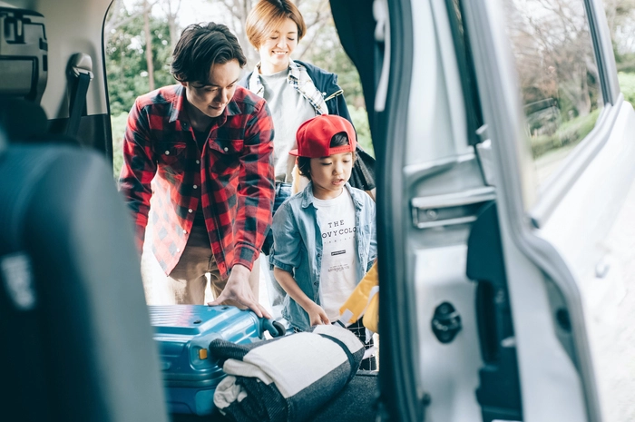 車に荷物を積んでいる家族