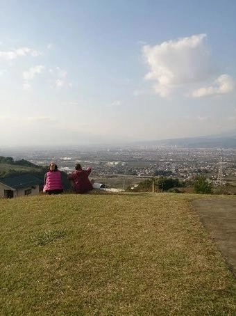 山梨県八代ふるさと公園の古墳から景色をみる人々