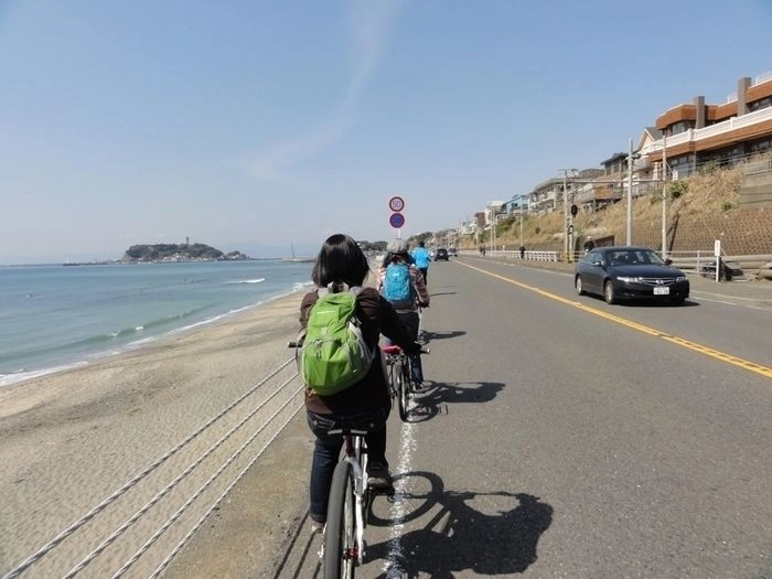 鎌倉ストリートサイクリングの海沿いをサイクリングする人の後ろ姿