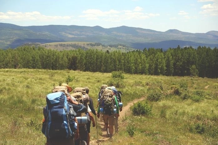 列になって平坦な道を歩く山登りの格好をした人々