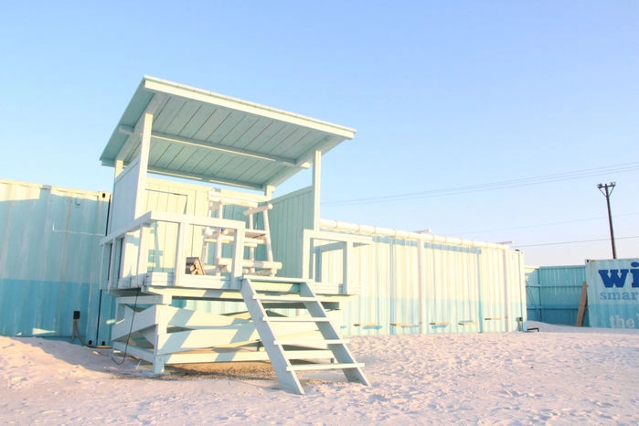 WILD BEACHの砂浜にあるテラスの建物の写真