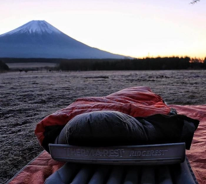 富士山を背景に地面に設置された寝袋