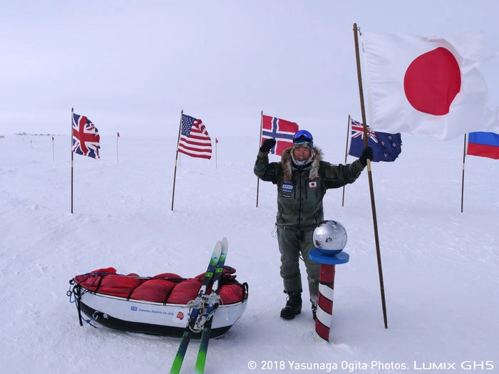 南極で日本の国旗を掲げる荻田泰永さん