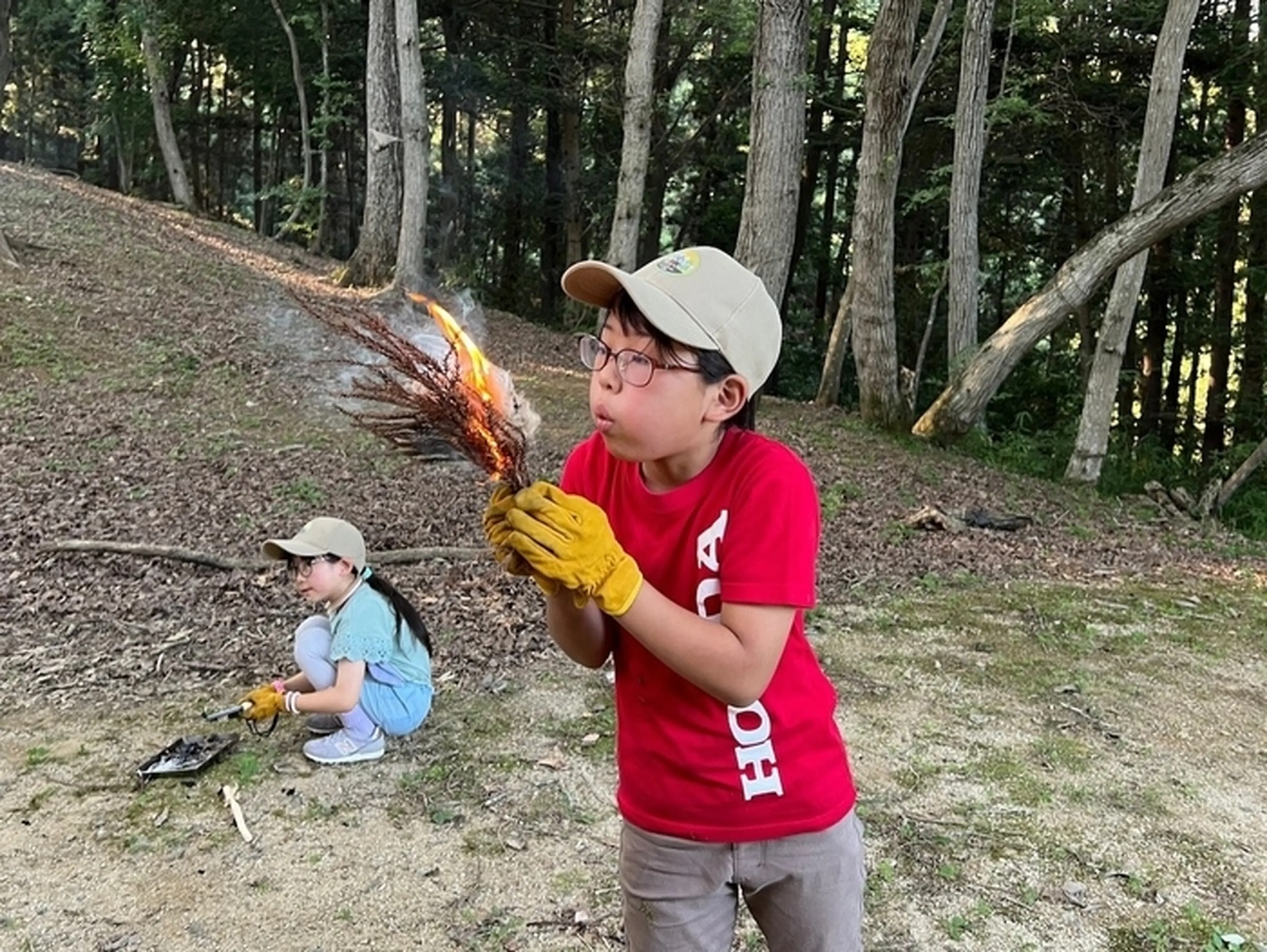 子供が木の枝に火をつけている